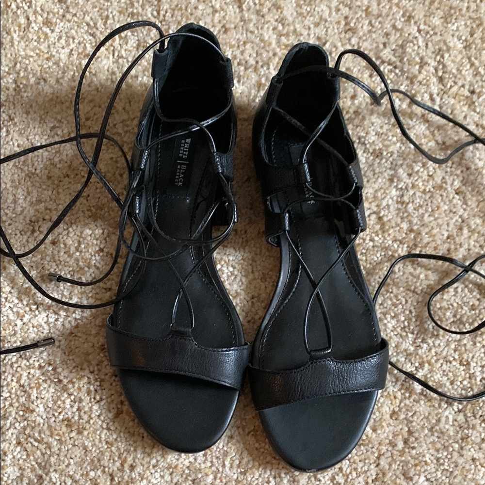 Black gladiator sandals with crisscross straps and adjustable laces